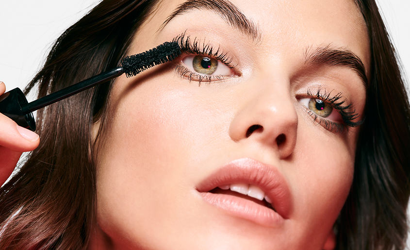 image shows lady applying mascara to eyelashes