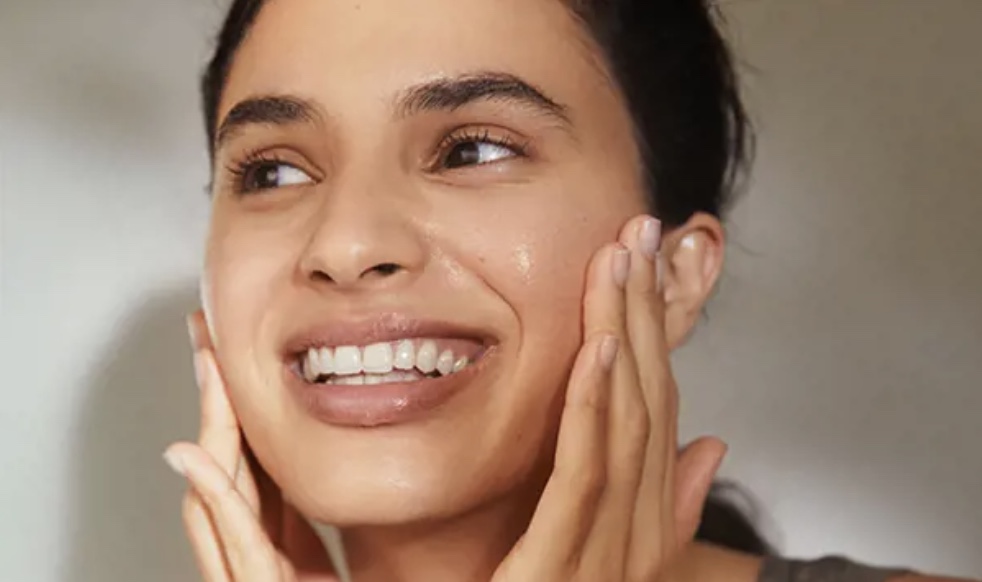image shows a lady applyig skincare to face